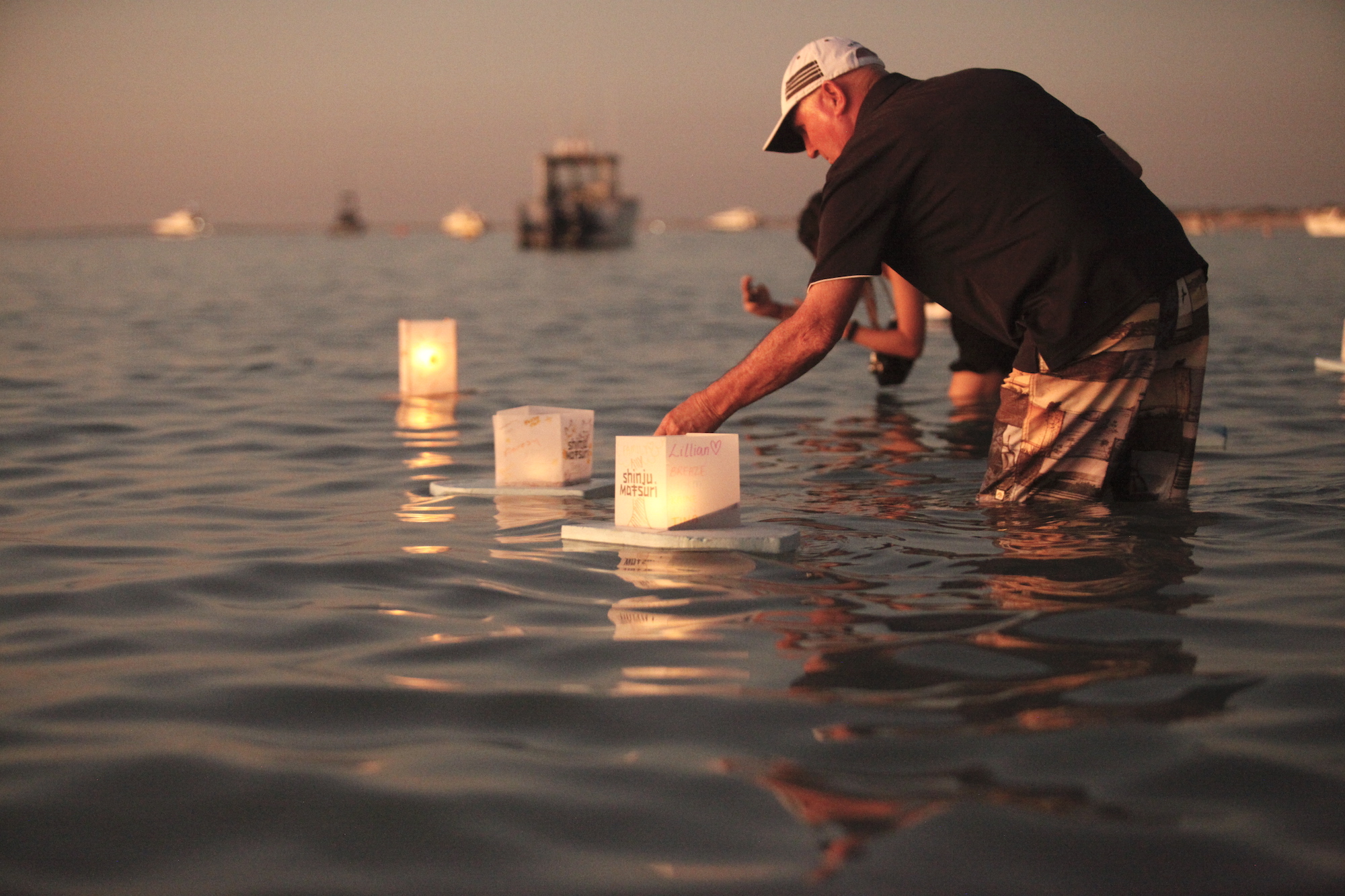 Floating lantern participant putting the candle on - Gantheaume point shinju matsuri